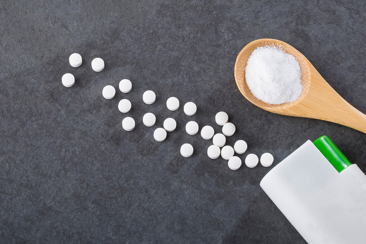 Süßungsmittel Tabletten auf grauem Hintergrund verstreut