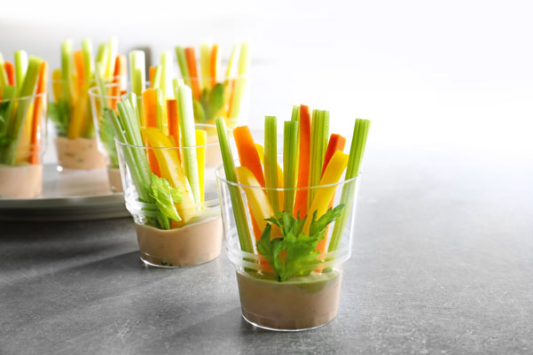 Gläser mit Dip und Gemüsesticks gefüllt