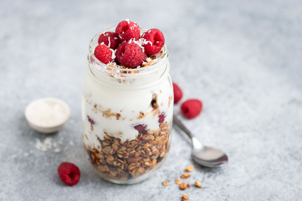 Glas mit Müsli, Joghurt und frischen Himbeeren