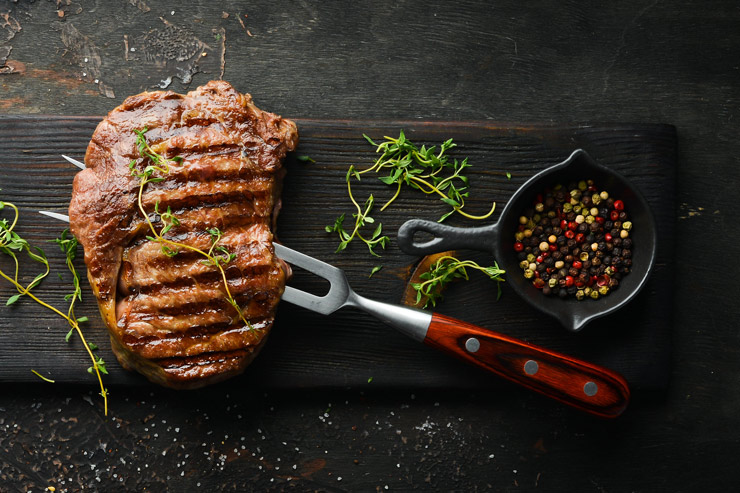 Gegrilltes Ribeye Steak, frische Kräuter und verschiedenen Pfefferkörnern