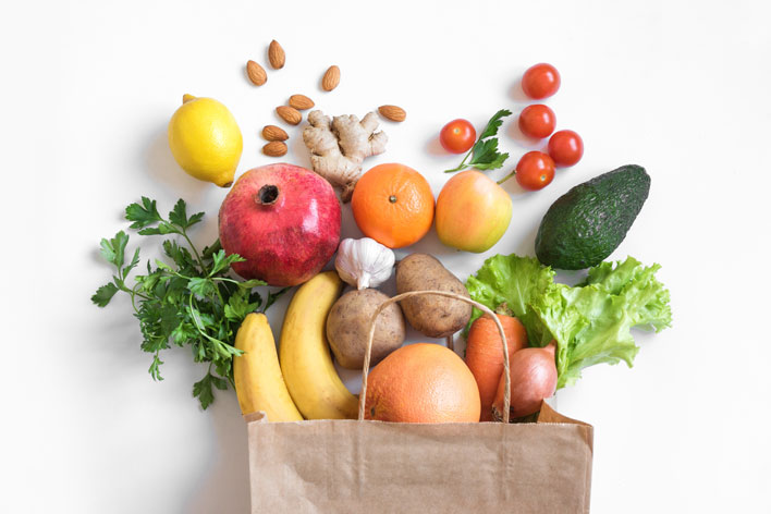 Papiertüte, befüllt mit Obst, Gemüse und Früchten als Symbol für natürliche Ernährung