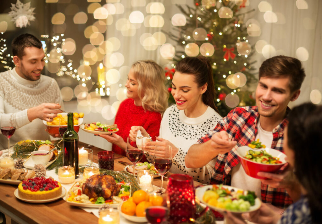 Fünf Junge Menschen sitzen rund um das Weihnachtsbuffet und speisen
