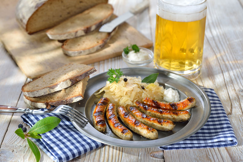 Nürnberger Rostbratwürste mit Sauerkraut, Meerrettich, Bauernbrot und ein Humpen Bier
